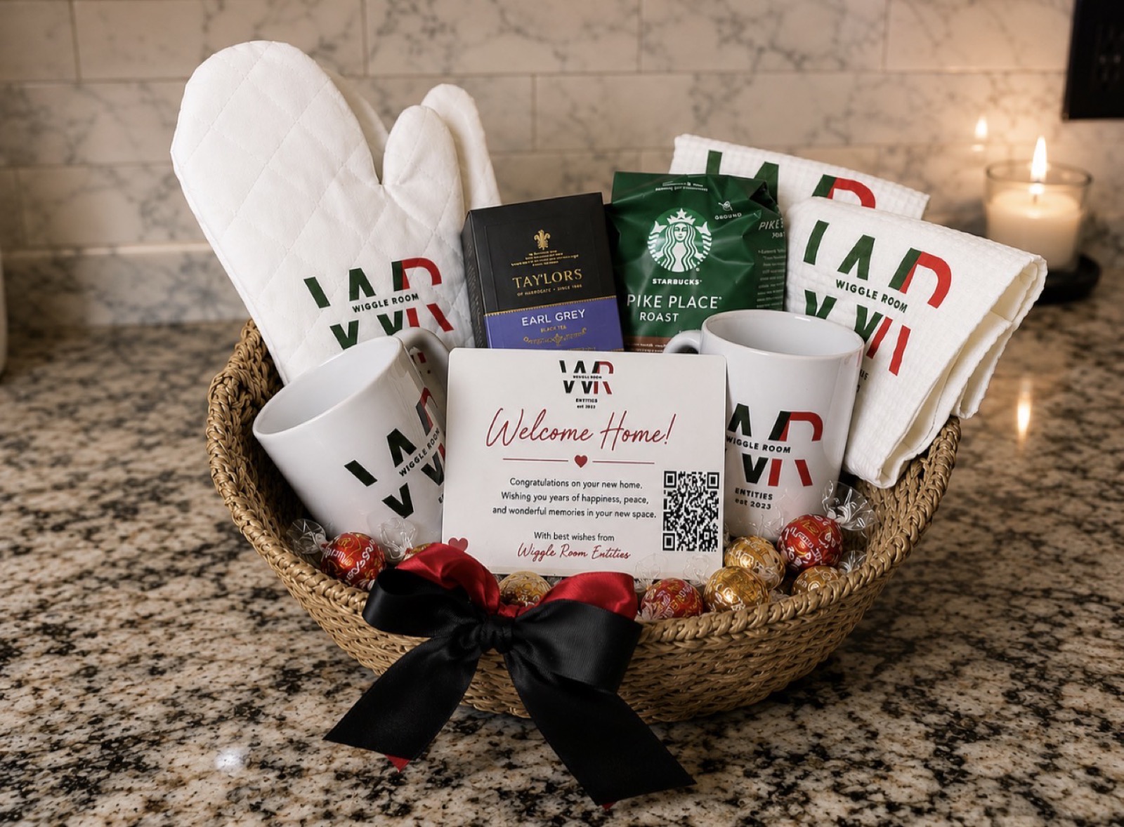 Branded corporate closing gift basket with logo mugs, oven mitts, kitchen towels and a Welcome Home card
